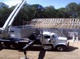 Girder truss being set on bearing wall at garage