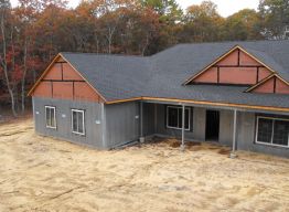 Shingles and hold-downs complete, windows in