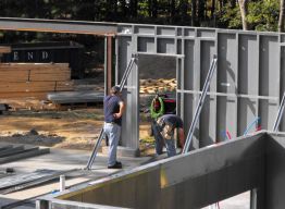 Bottom track for garage bearing wall installed